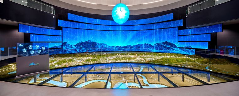 Immersive hall with a terrain model and a digital waterfall screen