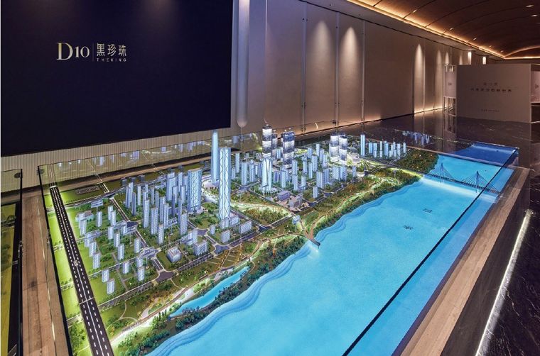 Model of a city with a river frontage inside a glass tank under blue light