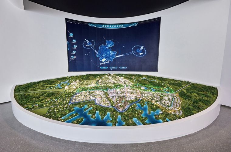 Regional model on an oval platform before a curved screen