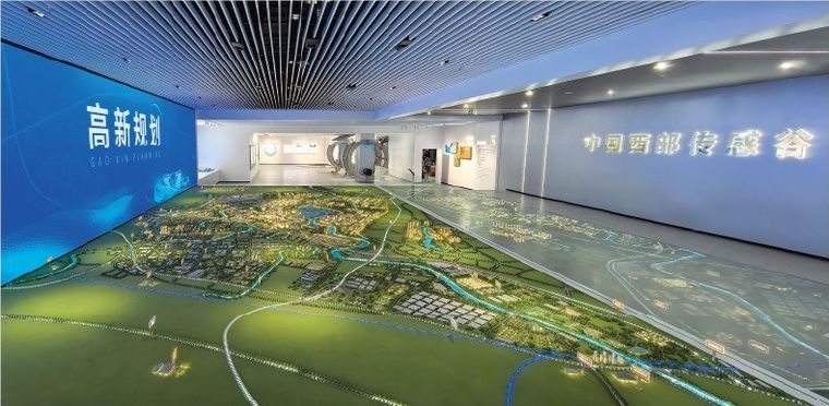 Regional model spread across a hall floor with a blue screen wall