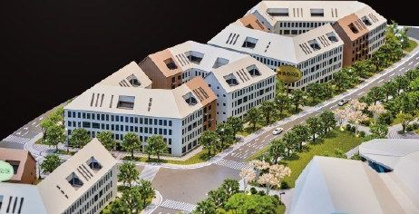 Model of an administrative building complex with tiled roofs and site landscaping