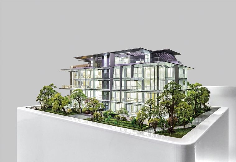 Model of a low-rise residential building with a glazed facade on a white base