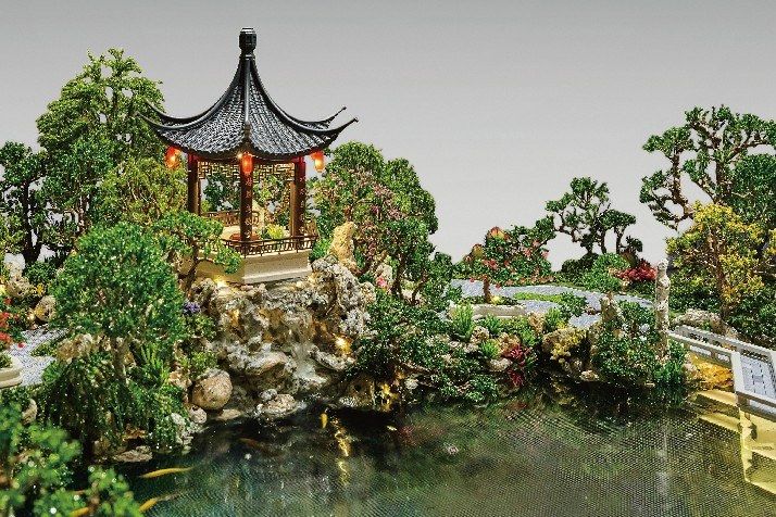 Model of a traditional pavilion within a rock garden with a fish pond