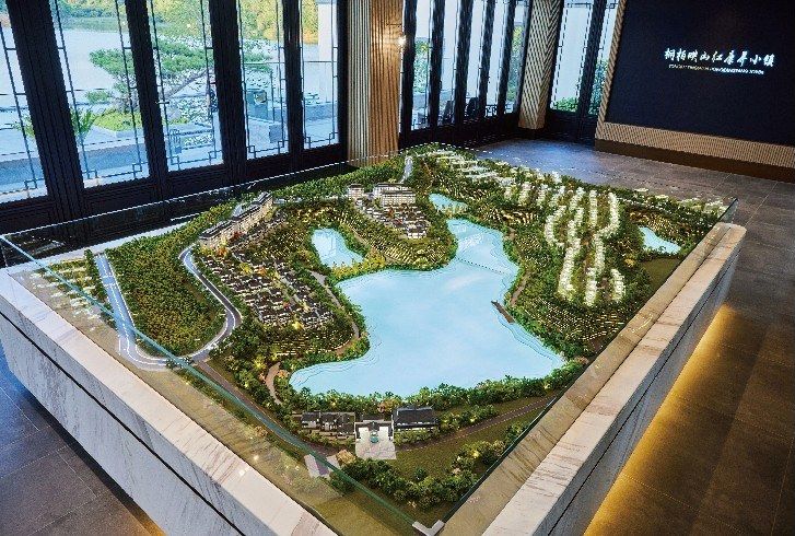 Model of a residential master plan around a lake on a marble base