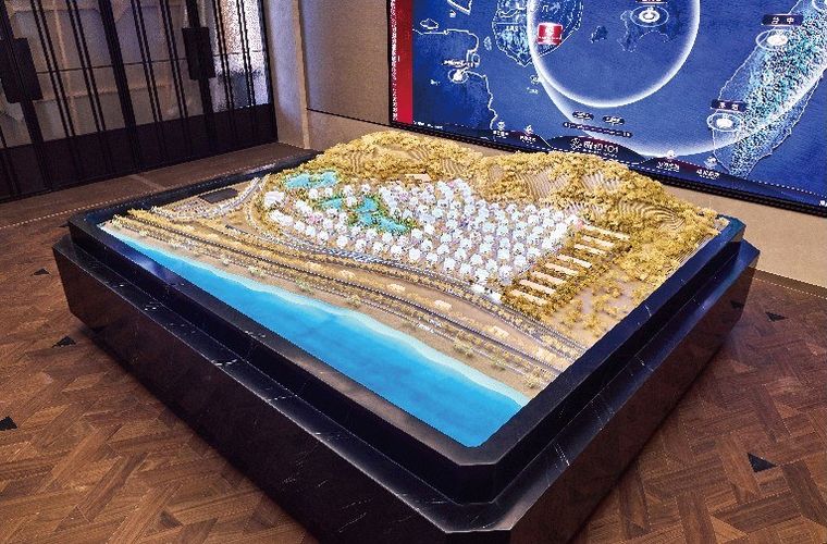 Model of a coastal project on sandy terrain before a blue map