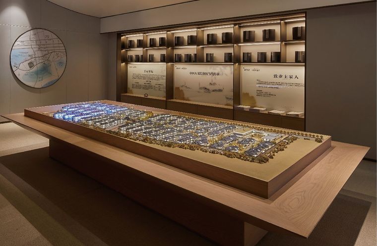 Model of a district of terraced villas before a wall of project panels