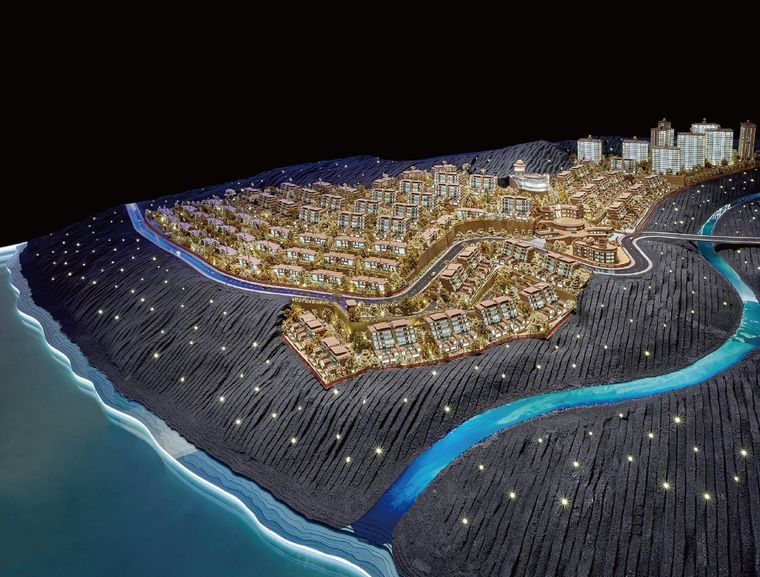 Model of a coastal project on a slope, lit in blue at night